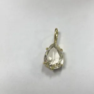 Primo piano del ciondolo in zircone a forma di pera, dettaglio di gioiello con montatura dorata.