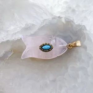 Gros plan détaillé d'un pendentif poisson en cristal rose, accessoire bijou en pierre.