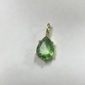 Primo piano dettagliato dell'elegante ciondolo in zircone cubico verde a goccia in oro.