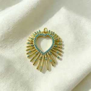 Detailed close-up of a gold-plated sunburst heart pendant with blue zircon stones.