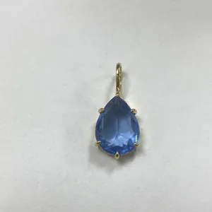 Primo piano dettagliato di un ciondolo in zircone cubico blu a forma di pera con montatura dorata.