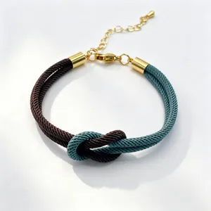 Close-up of the stylish braided couple bracelet featuring dual-color cords and gold metal accents.