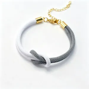 Two-tone braided Milan rope bracelet with figure-eight knot and gold-colored adjustable chain.