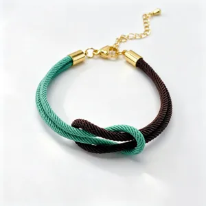 Detail shot of dual-color Milan rope braided bracelet with figure-8 knot and adjustable chain.