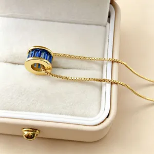 Vergulde cilindrische hanger ketting met blauwe zirkonia stenen detailweergabe sieraad