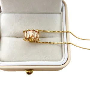 Gold plated necklace with sparkling baguette cubic zirconia wheel bead pendant in elegant velvet box.