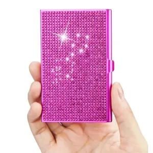 Vue rapprochée détaillée de l'étui à cartes en métal strass rose étincelant et texturé.