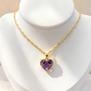 Vue détaillée d'un collier en chaîne dorée avec un superbe pendentif zircon cœur violet.