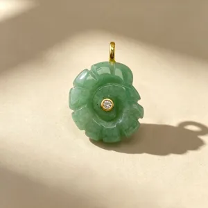Gros plan détaillé du pendentif conque sculpté en pierre naturelle verte avec incrustation et bélière.