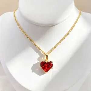 Gros plan détaillé du collier pendentif en cristal cœur rouge mettant en valeur sa belle coupe.