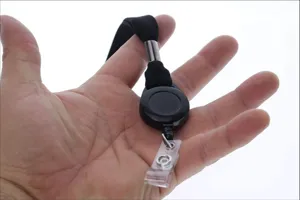 Primer plano detallado de un portatarjetas retráctil negro con cordón de nailon en mano.