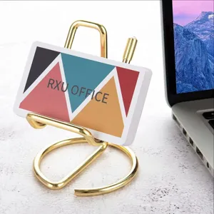 Gold metal desktop phone stand card holder close-up detail display minimalist office decor.