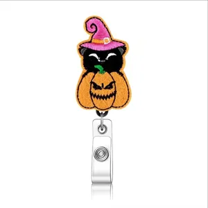 Close-up detail of Halloween felt black cat and pumpkin badge reel with fine embroidery.