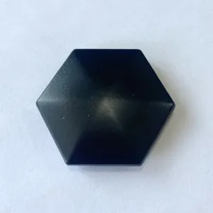 Detail view of black hexagonal metal kinetic desk toy piece, smooth matte surface for stress relief.