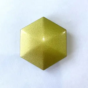 Close-up of gold hexagonal kinetic desk toy, smooth geometric fidget spinner surface.