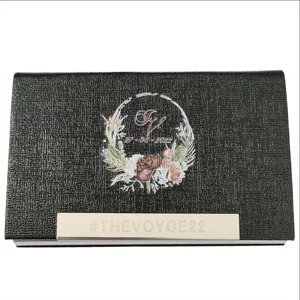 Vue rapprochée du porte-cartes de visite en cuir PU noir avec barre métallique et motif floral.