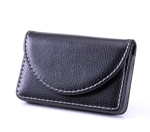 Black leather business card holder detail shot showing sleek curved flap and white stitching.
