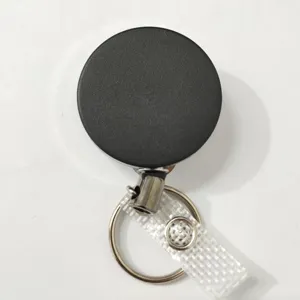 Close-up van de zwarte intrekbare badgehaspel met metalen sleutelhanger en een transparant bandje.