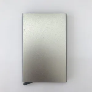 Estuche de tarjeta de crédito pop-up de aluminio metálico, detalle textura plateada.