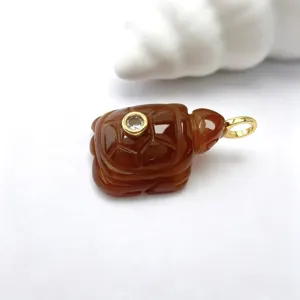 Vue rapprochée d'un pendentif tortue sculpté en pierre naturelle avec cristal.