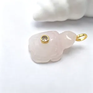 Vue détaillée du pendentif tortue en quartz rose, pierre précieuse polie avec bélière et cristal.