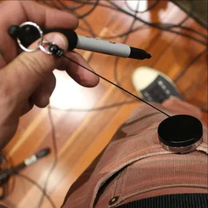 Detalle de portagafas retractil con cordon elastico fuerte y soporte para boligrafo.