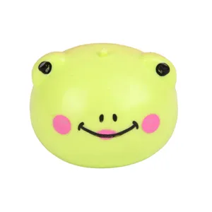 Close-up detail of cute green frog squishy stress relief toy with cheerful smile and soft texture.