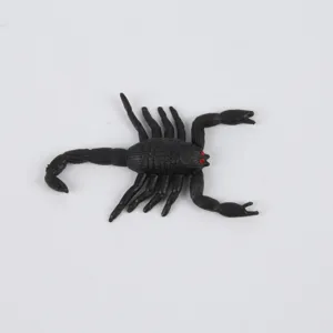 Primo piano dettagliato di un finto scorpione in plastica nera con occhi rossi per scherzi.