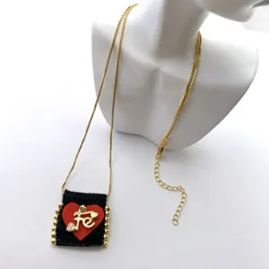 Gold box chain necklace featuring a handmade fabric pendant with letter detail and beads.