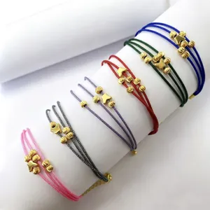 Bracciali intrecciati fatti a mano a più strati con perline dorate e ciondoli a farfalla.
