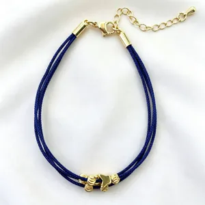 Elegante bracciale in corda blu multitraccia con ciondoli dorati e catena regolabile.
