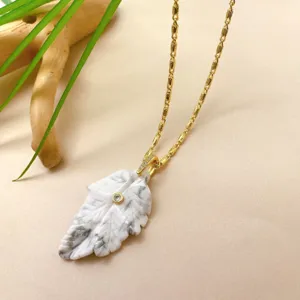 Collier pendentif en pierre de feuille blanche sculptée main, vue détaillée du bijou doré.