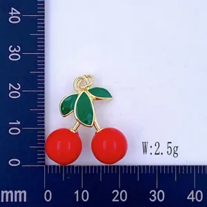 Cherry pendant detail showing 3D enamel design, gold-plated finish, and physical scale.