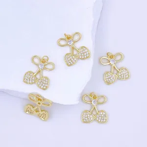 Close-up detail of shiny gold plated cherry heart pendants with sparkling clear cubic zirconia.