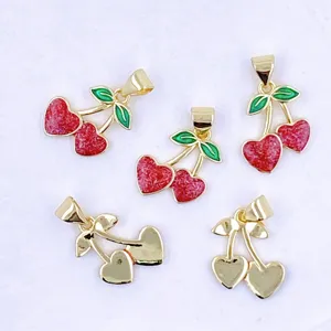 Nahaufnahme von goldenen Kirsch-Anhängern in Herzform mit rotem Glitzer für DIY Schmuck.
