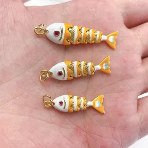 Detailopname van kleurrijke geëmailleerde beweegbare vis hangers met rode ogen voor sieraden.