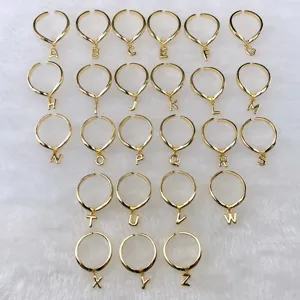 Detailaufnahme von goldenen verstellbaren Ringen mit 26 einzelnen Buchstaben-Anhängern.