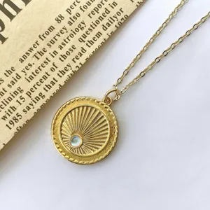 Detailed view of vintage gold sunburst coin necklace with sparkling center stone and fine chain.