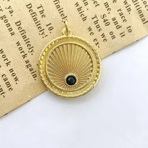 Detailed close-up of a retro gold sunray coin pendant featuring a central black zircon stone.