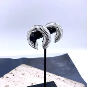 Detailed view of trendy European geometric C-shaped ribbed clip-on earrings, silver metal.