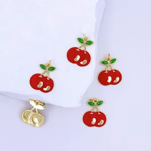 Close-up detail of sweet cherry pendant charm, alloy metal with red enamel and green leaves.