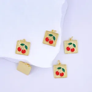 Gold square enamel cherry pendant detail showcasing cute fruit design and polished metal texture.