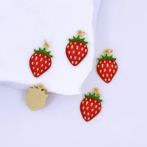Close-up of cute strawberry enamel pendant charms with gold trim for DIY jewelry.