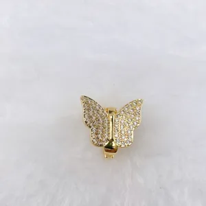 Detail shot of a golden butterfly charm with sparkling rhinestones, perfect for DIY jewelry crafting.