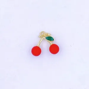 Close-up detail of the cute red cherry charm, featuring golden stem and glossy finish.