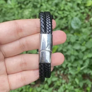Nahaufnahme eines mehrschichtigen, geflochtenen Lederarmbands mit glänzender Magnetverschluss.