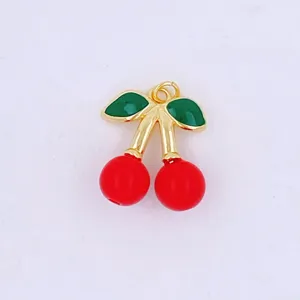 Close-up detail view of a 3D red cherry charm with green enamel leaves and gold trim.
