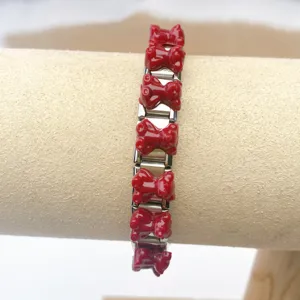 Detail shot of the stainless steel modular Italian charm bracelet with red decorative links.