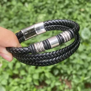Nahaufnahme des mehrschichtigen schwarzen geflochtenen Lederarmbands mit edelstahl Ringen.