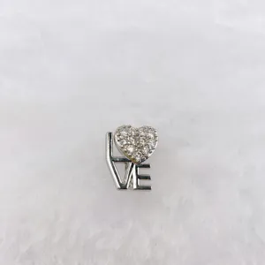 Close-up of a silver-toned metal DIY jewelry charm featuring a sparkling heart-shaped zirconia.